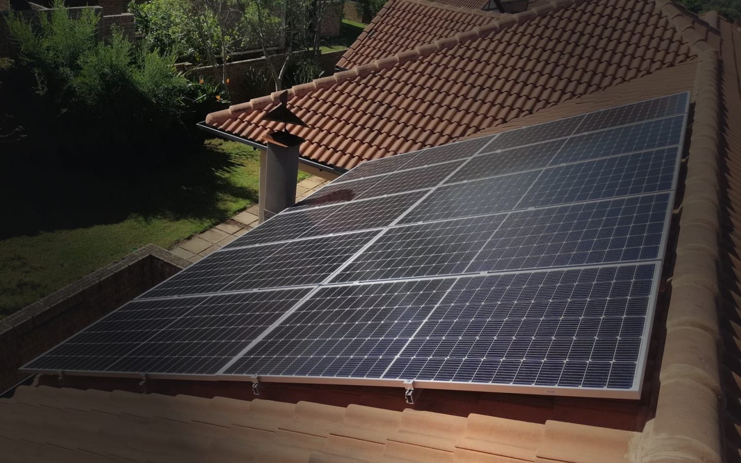Rooftop solar panels on a Jaipur-style urban home at sunset